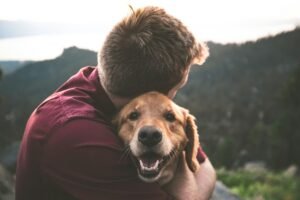 Person hugging their dog warmly outdoors