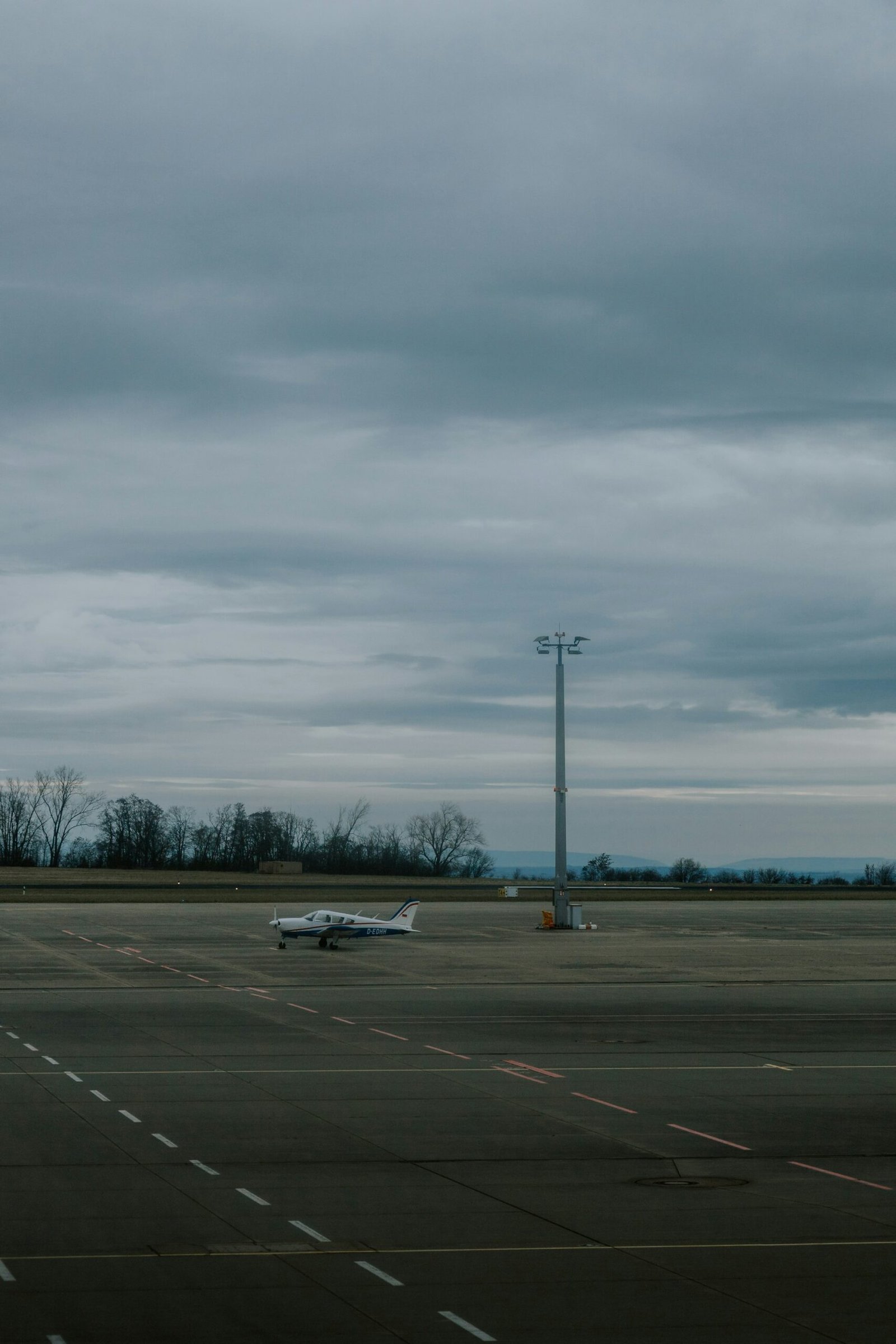 Small aircraft on an airfield under a cloudy sky